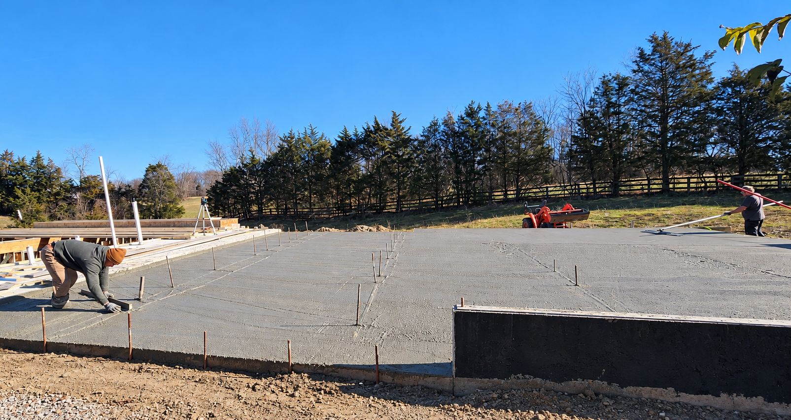 Crew finishing a freshly poured concrete slab with bull floats and hand tools